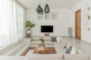 a white living room with a couch and a table at Casa Philip in Uluwatu
