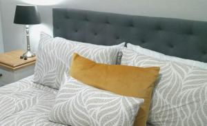 uma cama com almofadas brancas e uma cabeceira azul em Kennedy House Euroa A delightful place to stay em Euroa