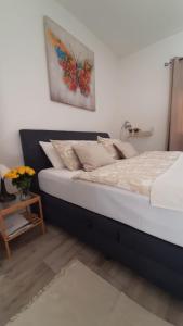 1 dormitorio con 1 cama con una pintura en la pared en Apartmani Alma en Pula