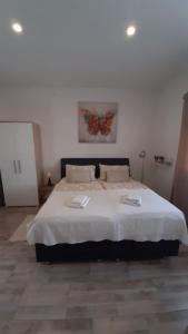 1 dormitorio con 1 cama grande con una pintura de mariposa en la pared en Apartmani Alma en Pula