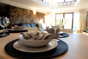 una mesa con un tazón, platos y copas de vino en Retiro de Gondramaz - Whole house, Casa inteira 200 m2 en Gondramaz