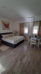 1 dormitorio con 1 cama, mesa y sillas en Apartmani Alma en Pula