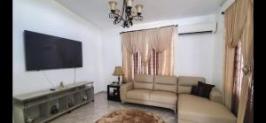 a living room with a couch and a flat screen tv at My dulce hogar in Isabela