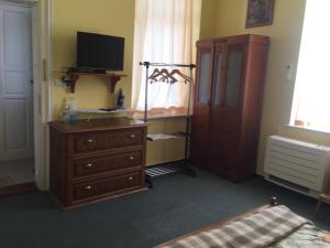 a bedroom with a dresser and a tv and a dresser with a dress at Art Studios Elsor in Burgas