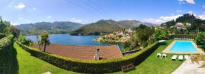 a house with a swimming pool and a lake at Verde Pinho in Geres