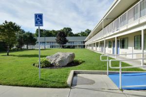 una señal de aparcamiento frente a un edificio en Motel 6-Tewksbury, MA - Boston, en Tewksbury