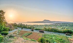 una vista desde una colina con la puesta de sol a lo lejos en Villa di Creta Heated Pool, en Kalyves