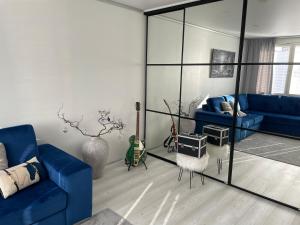 a living room with a blue couch and a mirror at Modern room in the city centre in Tampere