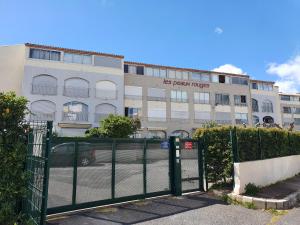 a building with a gate in front of a parking lot at C12 Deluxe in Cap d'Agde
