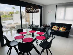 a living room with a table and chairs with red umbrellas at Mil Palmeras - Bioko 208 - apartment for 6 in Pilar de la Horadada