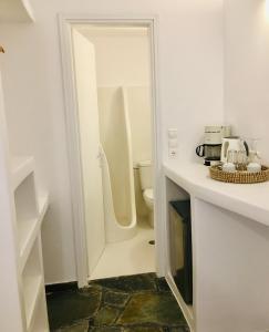 a white bathroom with a toilet and a sink at Nostos Studios in Parikia