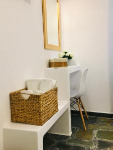 a white shelf with a basket and a mirror at Nostos Studios in Parikia