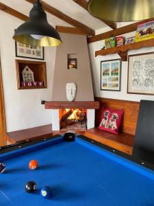 una mesa de billar en una habitación con chimenea en Angliiska Vila en Arbanasi