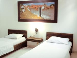1 dormitorio con 2 camas y un cuadro en la pared en Hotel Houston, en Bucaramanga