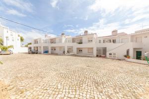 a cobblestone parking lot in front of white buildings at Church Square Apartment in Praia da Luz in Luz