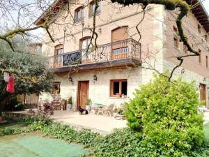 un edificio con balcón y un gato sentado en el patio en Alojamiento Rural Abuela Andrea, en Molinilla