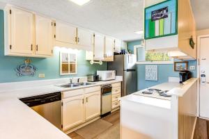 a kitchen with white appliances and blue walls at Sunnyside Beach & Tennis #54 in Panama City Beach