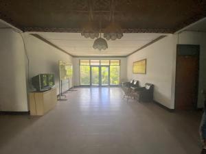 un salon vide avec une télévision et un canapé dans l'établissement OYO 91073 Rantepao Lodge, à Rantepao