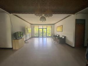 an empty living room with a television and a couch at OYO 91073 Rantepao Lodge in Rantepao