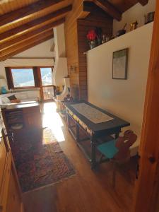 a living room with a table and a wooden floor at Mansarda in chalet a Cortina in Cortina dʼAmpezzo