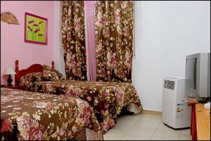 a hotel room with two beds and a tv at Apartamento El Carmen in Barbate