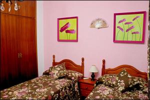 バルバテにあるApartamento El Carmenのベッドルーム1室(ベッド2台付)が備わります。壁に2枚の写真が飾られています。