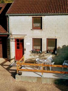 a patio with a table and chairs in front of a building at Gite à la Ferme in Rouvroy