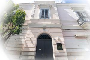 a white building with a black door and a window at DEAS B&B in Trani