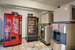 a cocacola soda machine and a refrigerator in a kitchen at Motel 6-Wethersfield, CT - Hartford in Wethersfield