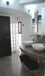 タリファにあるApartamento El Cuartonのバスルーム(石造りのカウンターに洗面台2台付)
