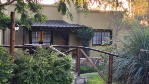 una casa con una barandilla de madera delante de ella en Posada del Santo Green & Rest - Cabañas en Salta