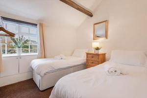 une chambre avec deux lits et une fenêtre dans l'établissement Cottage 2, Old Farmhouse Mews, à Braithwaite