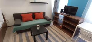 ブダペストにあるOsvat Apartmentsの小さなリビングルーム(ソファ、テレビ付)