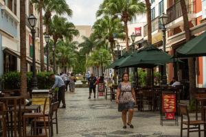 a woman walking down a street with tables and chairs at ibis Rio de Janeiro Nova America in Rio de Janeiro
