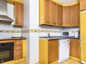 a kitchen with wooden cabinets and a white dishwasher at Apartamento 358 in Marbella