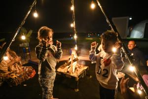 Due bambini giocano sulle altalene di notte di Siniya Island Leisure Campground Umm Al Quwain a Umm Al Quwain
