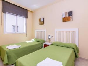 2 camas en una habitación con sábanas verdes en Apartamento 341, en Marbella