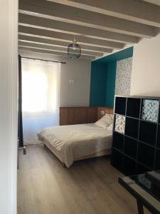 Un dormitorio con una cama grande y una ventana en Duplex avec poêle à granulés et garage à motos en Montaigut-le-Blanc