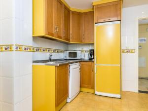 cocina con armarios de madera y nevera amarilla en Apartamento 362, en Marbella