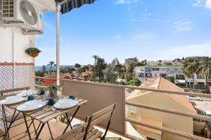a balcony with tables and chairs and a view of the city at Cozy estudio in Benalmádena in Benalmádena