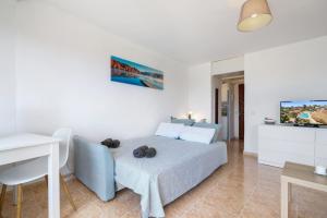 a bedroom with a bed and a table and a television at Cozy estudio in Benalmádena in Benalmádena