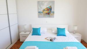 ein Schlafzimmer mit einem Bett mit blauen Kissen und einem Gemälde in der Unterkunft Sea View Apartment in Hvar