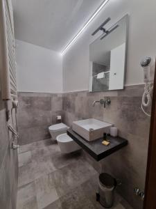 y baño con lavabo, aseo y espejo. en B&B The Lux en Florence