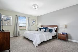a white bedroom with a bed and a window at 5Br 5Bath Pvt Home BBQ Pool 10min Disney 3077ft in Kissimmee