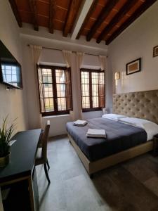 1 dormitorio con 1 cama, escritorio y ventanas en B&B The Lux en Florence