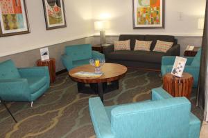 a waiting room with blue chairs and a table at Baymont by Wyndham Flagstaff in Flagstaff