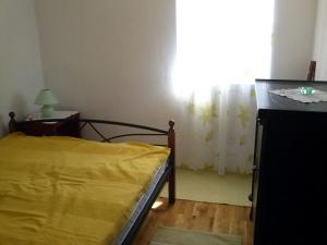 Un dormitorio con una cama amarilla y una ventana en Holiday Home Tomislav en Komiža