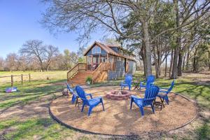 a group of blue chairs in front of a cabin at Cozy McKinney Tiny Home with Porch and Fire Pit! in McKinney