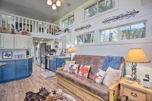 a living room with a couch and a kitchen at Cozy McKinney Tiny Home with Porch and Fire Pit! in McKinney