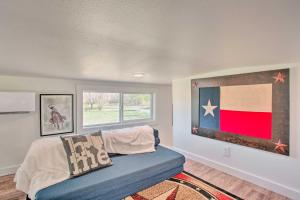 uma sala de estar com um sofá e uma bandeira na parede em Cozy McKinney Tiny Home with Porch and Fire Pit! em McKinney
